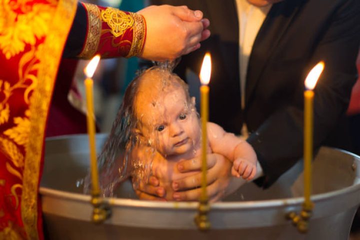 Baptism of a newborn child.The rite of Orthodox baptism. The child is watered with water.